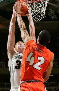 MSU center Drew Naymick goes up for a dunk while Illinois forwad Brian Randle attempts to block the shot.