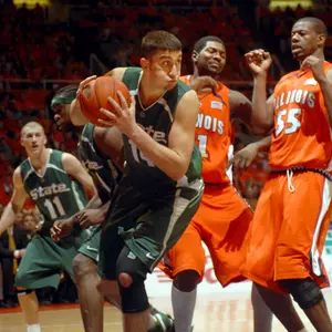 Goran Suton looks to make a pass after grabbing a rebound as Illinois' Brian Carlwell looks on during the first half at Assembly Hall Tuesday night. (AP Photo/Heather Coit)