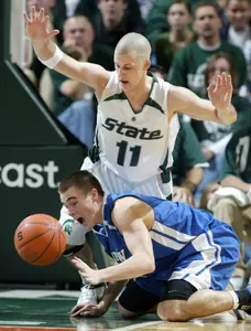 Drew Neitzel and IPFW's Zach Plackemeier fight for a loose ball during the first half. (AP Photo/Al Goldis)