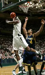 Spartan forward Raymar Morgan puts up a shot around Michigan defender Courtney Sims. Morgan shot 6-8 from the field during the second half and scored 14 points.