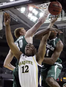 Marquette's Dwight Burke is fouled as he goes to the basket by Marquise Gray.