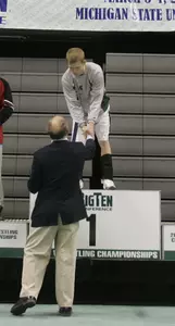 Nick Simmons accepts his first-place medal on Sunday after winning the 133-pound title at the Big Ten Wrestling Championships.