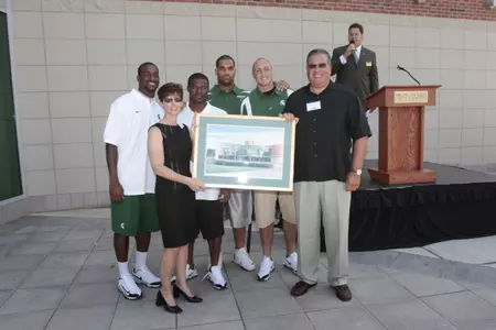 The captains present Bob and Julie Skandalaris a gift at Thursday's dedication ceremony.