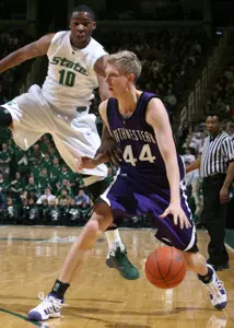 Delvon Roe leaps to defend against Northwestern's Kevin Coble during the first half. (AP Photo/Al Goldis)