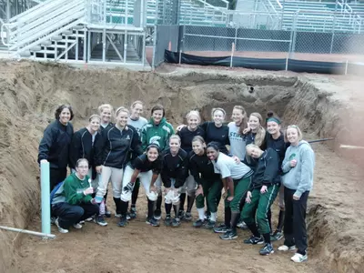 The 2010 Spartan softball team takes a break from practice to pose in the hole where one of the new dugouts will be constructed.