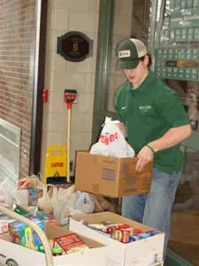 Freshman Torey Krug of the hockey team gathers food donated for the Holiday Food Drive.