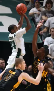 Korie Lucious shoots over Iowa's Cyrus Tate in the first half.