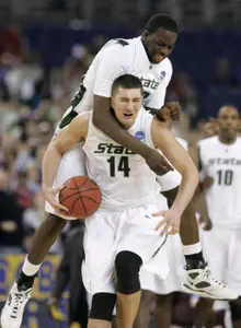 Draymond Green jumps onto Goran Suton in celebration following the win.