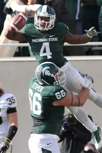 John Stipek holds up Edwin Baker after Baker's 19-yard touchdown run in the second quarter.
