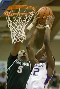 Michigan State center Adreian Payne (5) and Washington forward Justin Holiday (22) go up for a rebound in the first half.