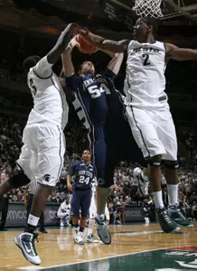 Penn State's Andrew Ott (54) puts up a shot between Michigan State's Draymond Green, left, and Raymar Morgan (2) during the first half of an NCAA college basketball game, Thursday, March 4, 2010, in East Lansing, Mich. (AP Photo/Al Goldis)
