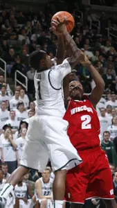 Michigan State's Kalin Lucas (1) and Wisconsin's Wquinton Smith (2) reach for a rebound during the first half. (AP Photo/Al Goldis)