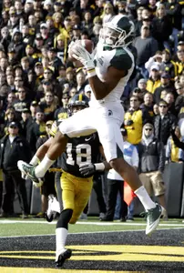 Michigan State wide receiver B.J. Cunningham catches a touchdown pass over Iowa cornerback Micah Hyde. (AP Photo/Charlie Neibergall)