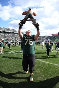 Jared McGaha carries the Paul Bunyan Trophy following MSU's 28-14 win over Michigan on Oct. 15. McGaha went 4-0 against Michigan in his career.