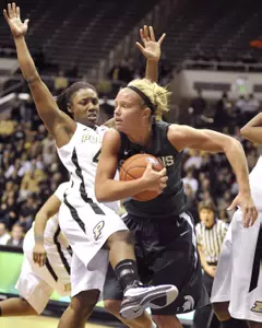 Courtney Schiffauer grabs a rebound in front of Purdue guard Chantel Poston.