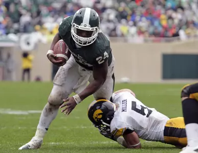 Le'Veon Bell rushes against Iowa's Tanner Miller.