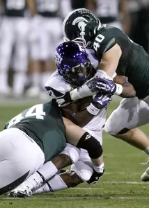 TCU running back B.J. Catalon, center, is tackled between defensive end Marcus Rush, left, and linebacker Max Bullough, right. (AP Photo/Paul Connors)