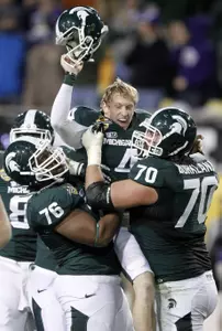 Dan Conroy is mobbed by his teammates after his 47-yard game-winning field goal.