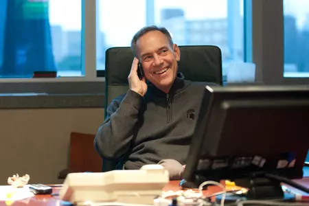 Mark Dantonio flashes a smile while visiting with Booker High School defensive back Ezra Robinson on the phone Wednesday morning.