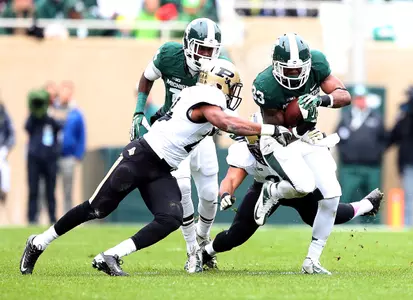 Jeremy Langford runs the ball, beating Boilermaker defenders.