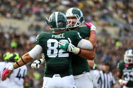 Jack Conklin congratulates Josiah Price after Price caught a 2-yard touchdown pass in the second quarter during MSU's 45-31 win at Purdue on Saturday.