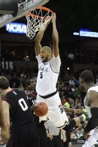 Michigan State Spartans forward Adreian Payne dunks against Harvard Crimson guard Laurent Rivard in the second half.