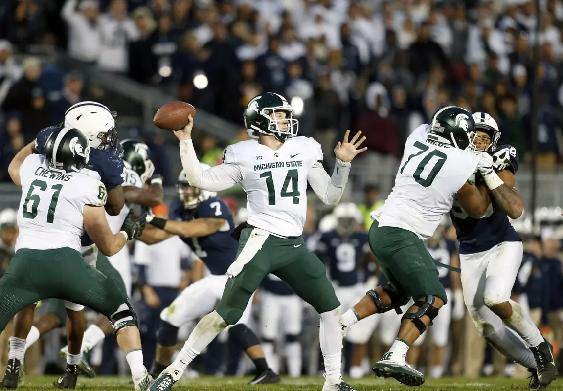 Michigan State quarterback Brian Lewerke (14) throws a pass against Penn State during the second half of an NCAA college football game in State College, Pa., Saturday, Oct. 13, 2018. (AP Photo/Chris Knight)