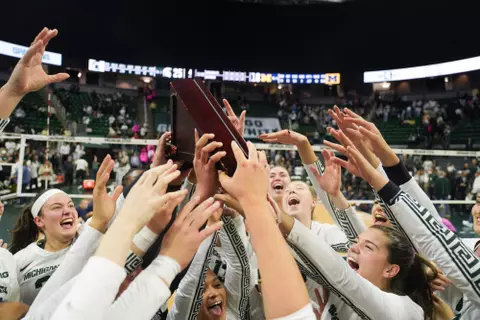 Volleyball team celebrates with state pride flag, 2023