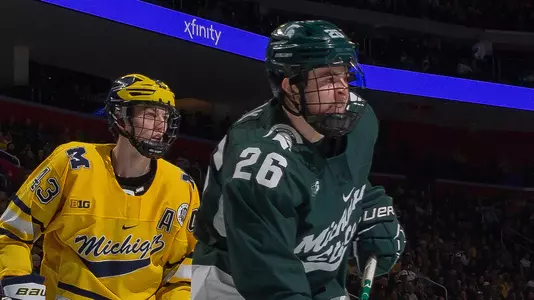 DETROIT, MI - FEBRUARY 11: Tanner Kelly #26 of the Michigan State Spartans sets up in front of Erik Portillo #1 and Luke Hughes #43 of the Michigan during the first period of an NCAA MenÕs college hockey Dual in the D game at Little Caesars Arena on February 11, 2023 in Detroit, Michigan. The Wolverines defeated the Spartans 4-3 in O.T. (Photo by Dave Reginek/Getty Images) *** Local Caption *** Tanner Kelly; Erik Portillo; Luke Hughes