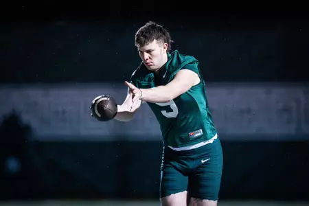 Rhys Dakin punts during spring practice.
