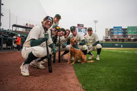 Group of Michigan State baseball players with Zeke the Wonder Dog at Crosstown Showdown.