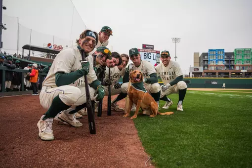 Group of Michigan State baseball players with Zeke the Wonder Dog at Crosstown Showdown.