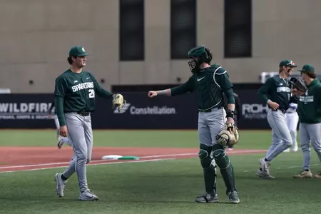 Aidan Donovan and Adam Broski fist bump after inning
