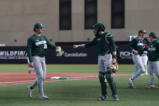 Aidan Donovan and Adam Broski fist bump after inning