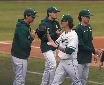 Nolan Higgins and Carter Monke high five with teammates