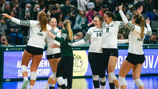 Volleyball celebrates in a huddle against UCLA