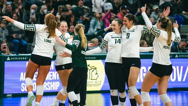 Volleyball celebrates in a huddle against UCLA