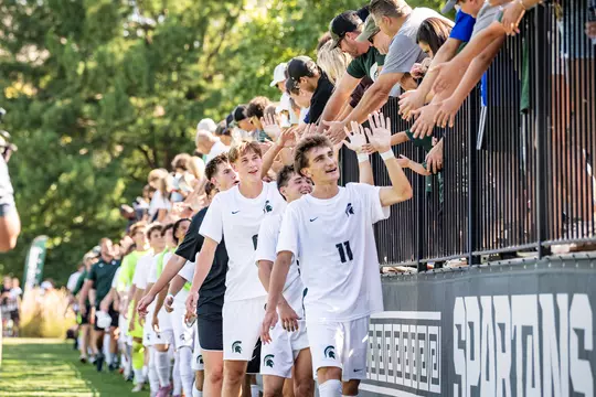 Men's Soccer high fiving fans