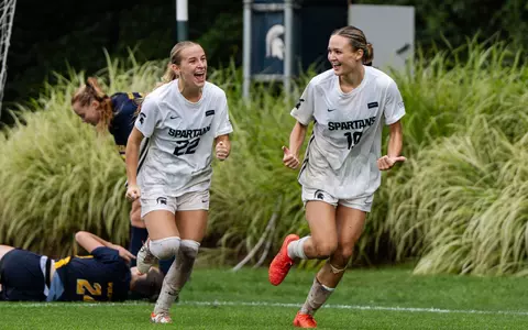 Ella Janz and Emerson Sargeant celebrate a goal against Michigan