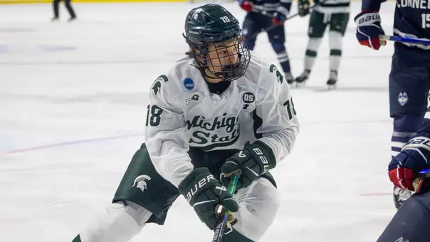 Ryker Lee controls the puck near the boards against UConn in the NCAA Tournament