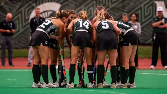 The Michigan State field hockey team huddles on the field