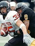 Texas Tech running<br>back Shaud Williams<br>is wrapped up behind<br>the line of scrimmage<br>by Missouri safety<br>Clarence Jones Saturday.