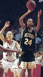 Missouri's Amanda Lassiter passes as Arkansas' Wendi Willits defends during the Tigers' NIT overtime loss, Saturday.