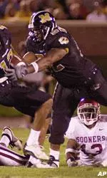 Missouri wide receiver Justin Gage (12) runs into teammate Tony Palmer (52) after getting past Oklahoma defenders Jonathan Jackson (49) and Eric Bussey during the second quarter in Columbia, Mo., Saturday, Oct. 5, 2002. Gage kept his balance and gained 46 yards on the play. Gage set a school record for career catches during the game.
