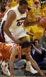 Arthur Johnson dribbles past Texas' Freddie Williams during the first half Sunday.