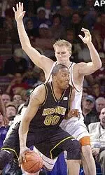 Arthur Johnson tries to drive past Texas' Jason Klotz in the first half of a Big 12 Conference tournament quarterfinal game.