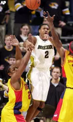 Jason Conley passes the ball over Iowa State's Curtis Stinson, right, and Damon Staple, left, during the first half.