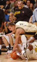 Missouri's Keven Young, bottom, and Oakland, Mich.'s Vova Severovas, top, get tangled up while going for a loose ball in front of the Missouri bench during the first half of a college basketball game Friday, Dec. 30, 2005, in Columbia, Mo. (AP Photo/L.G. Patterson)