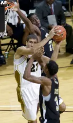 Justin Safford, center, shoots past Arkansas-Pine Bluff's George Davis, top, and Dominic Moore, bottom, during the first half.