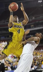 Missouri's J.T. Tiller (4) goes up for a shot against Memphis' Antonio Anderson during the first half of a men's NCAA college basketball tournament regional semifinal. (AP Photo/Mark J. Terrill)